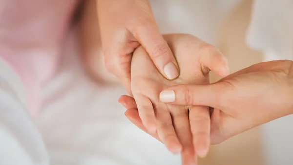 Giovane donna ottenere massaggio della mano — Foto Stock