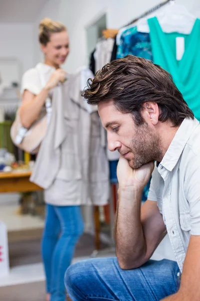 Man in front of girlfriend in clothing store — Stock Photo, Image