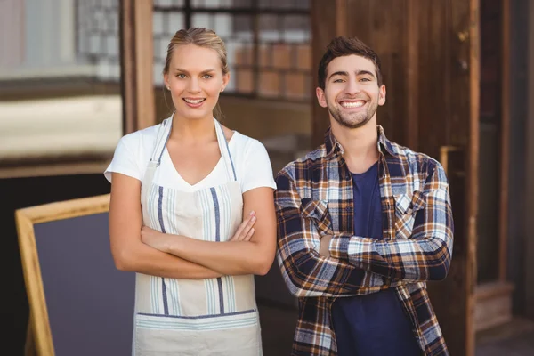 Lachende serveerster en haar collega met gekruiste armen — Stockfoto