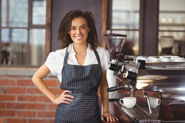 Jolie barista souriant à côté de la machine à café — Photo