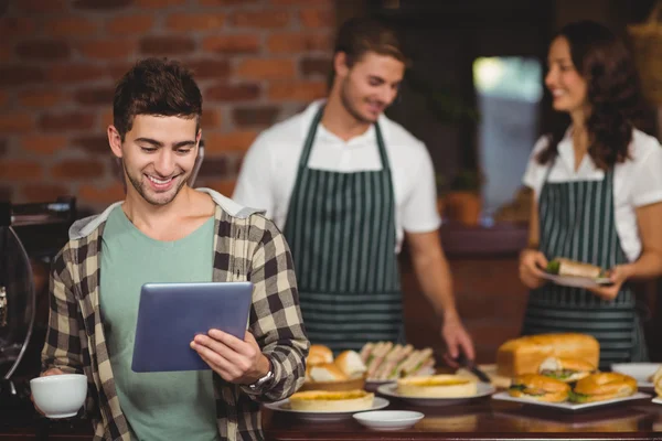 Lachende klant kijken naar Tablet PC — Stockfoto