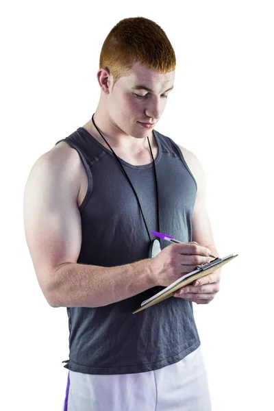 Fit personal trainer writing on clipboard — Stock Photo, Image