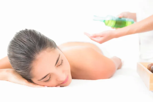 Beautiful brunette enjoying an oil massage — Stock Photo, Image