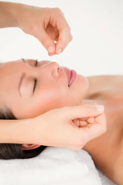 Hands threading beautiful woman's face — Stock Photo, Image