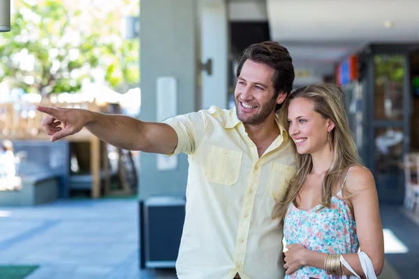 Pareja mirando y apuntando al centro comercial — Foto de Stock