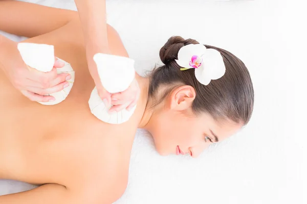 Brünette genießt Kräuterkompresse Massage — Stockfoto