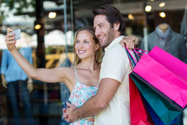 Paar umarmt und macht Selfies — Stockfoto