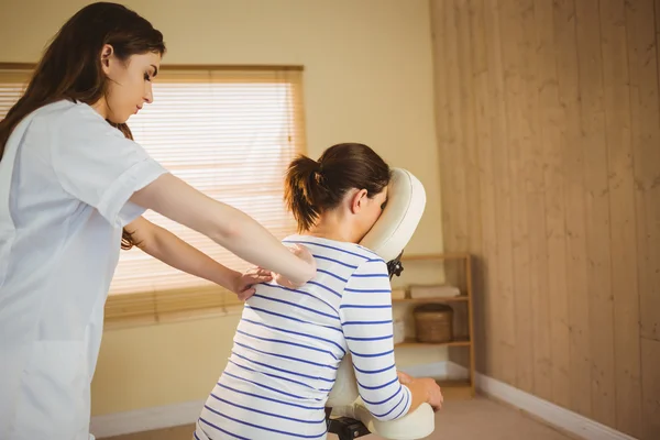 Joven mujer recibiendo masaje en silla — Foto de Stock