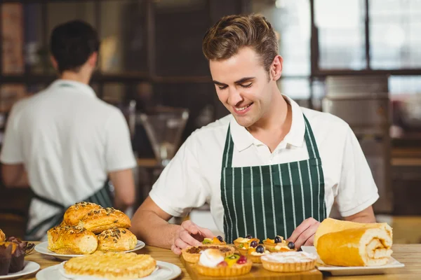 Leende servitör städa bakverken — Stockfoto