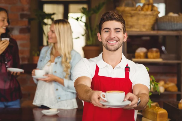 Camarero guapo entregando una taza de café — Foto de Stock