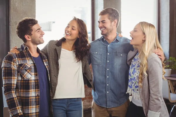 Glimlachend vrienden lachen en armen rond elkaar zetten — Stockfoto