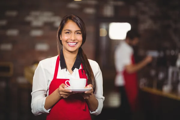 Camarera sonriente sosteniendo una taza de café — Foto de Stock