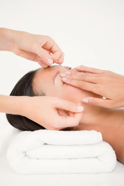 Hands threading woman's eyebrow — Stock Photo, Image