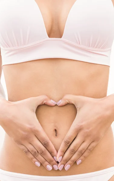 Fit mujer haciendo forma de corazón en el vientre — Foto de Stock