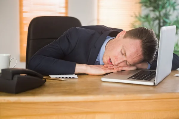 Exhausted businessman sleeping on his laptop — Stock Photo, Image