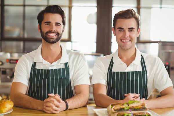 Δύο χαμογελαστά baristas εξετάζοντας τη φωτογραφική μηχανή — Φωτογραφία Αρχείου