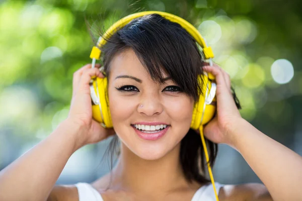 ผู้หญิงสวมหูฟังสีเหลือง — ภาพถ่ายสต็อก