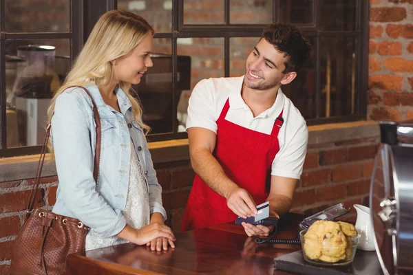 Garçom sorrindo passando o cartão de crédito — Fotografia de Stock