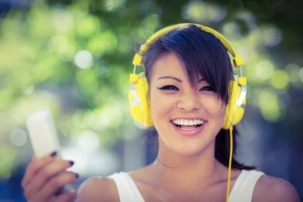 Mulher usando fones de ouvido amarelos — Fotografia de Stock