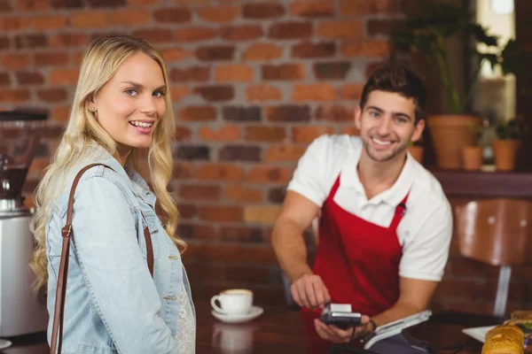 Smiling waiter using the pin terminal — Stock Photo, Image