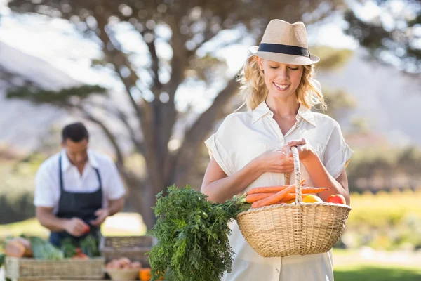 Blonde vrouw met een mand fruit — Stockfoto