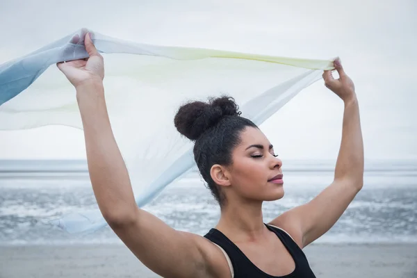 Подходящая девушка, стоящая с шарфом, развевающимся на ветру — стоковое фото