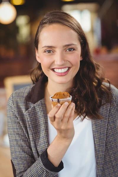 Uśmiechnięta młoda kobieta Wyświetlono muffin — Zdjęcie stockowe