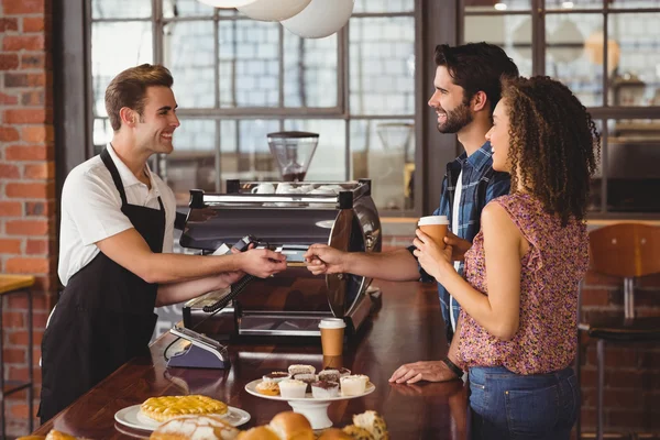 Sonriente hipster dando tarjeta de crédito a barista — Foto de Stock