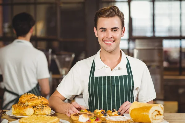 Camarero sonriente ordenando los pasteles — Foto de Stock