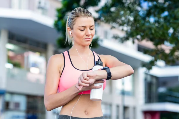 En vacker friidrottare tittar henne titta på — Stockfoto