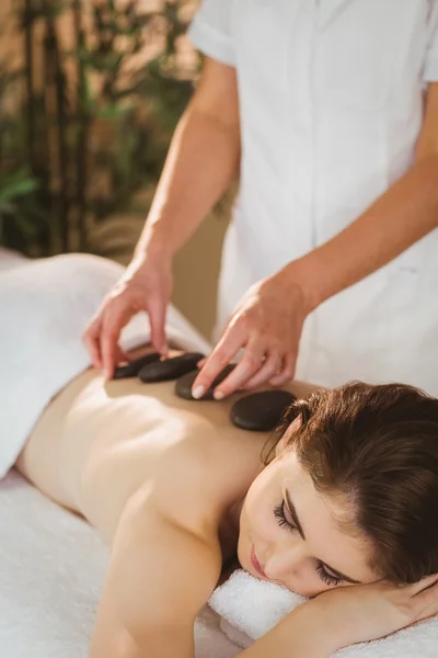 Kobieta coraz masaż gorącymi kamieniami — Zdjęcie stockowe