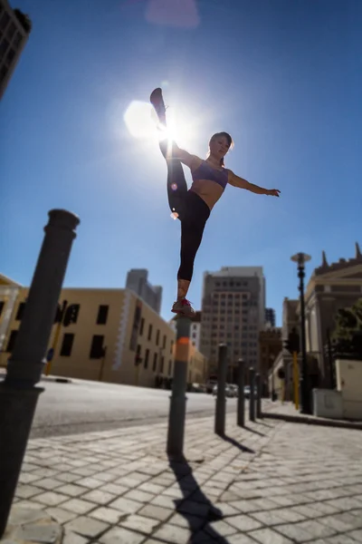 Athletic woman balancing on bollard — Stock Photo, Image