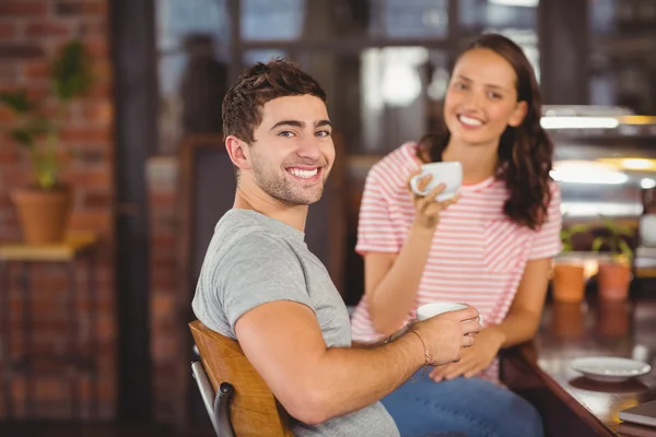 Amigos sorridentes sentados e bebendo café — Fotografia de Stock