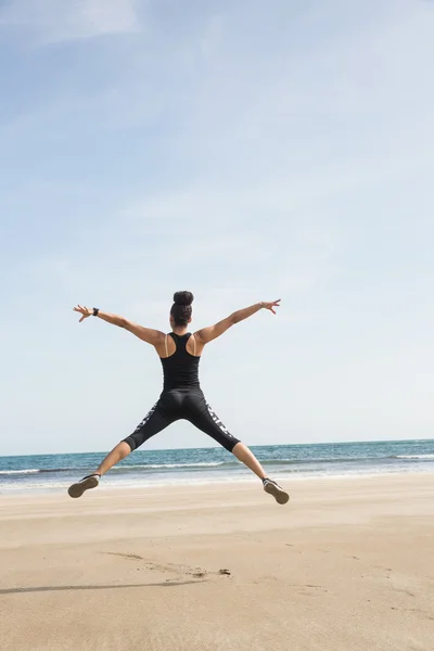 Fit woman leaping on the sand — Stock Photo, Image