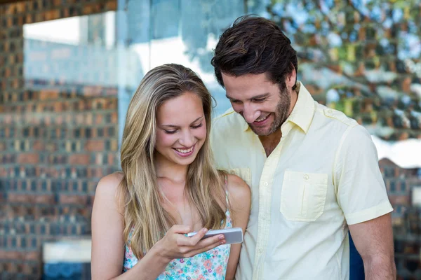 Lächelndes Paar schaut aufs Smartphone — Stockfoto