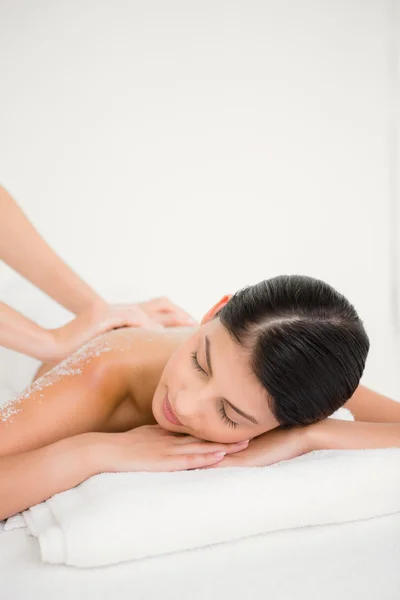 Mulher desfrutando de uma massagem de esfoliação de sal — Fotografia de Stock