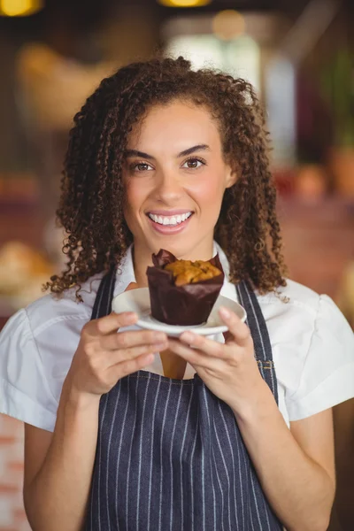 Chelneriță zâmbitoare ținând o brioșă — Fotografie, imagine de stoc