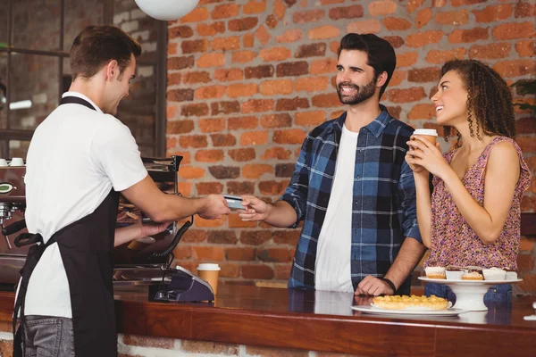 Sonriente hipster dando tarjeta de crédito a barista — Foto de Stock