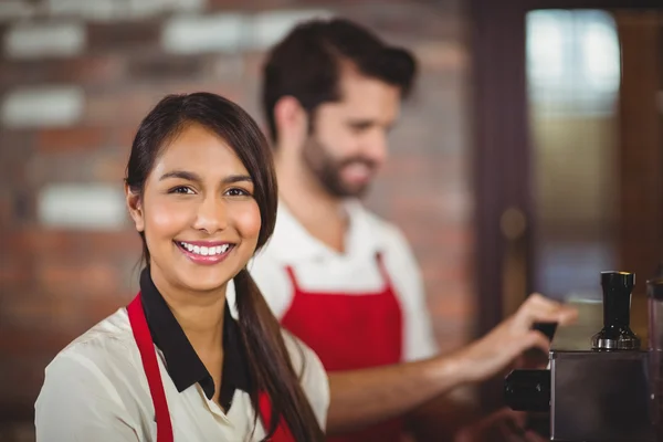 Uśmiechnięta kelnerka za pomocą ekspresu do kawy — Zdjęcie stockowe