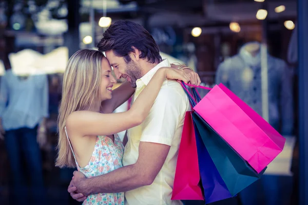 Alışveriş torbaları ile sarılma couple — Stok fotoğraf