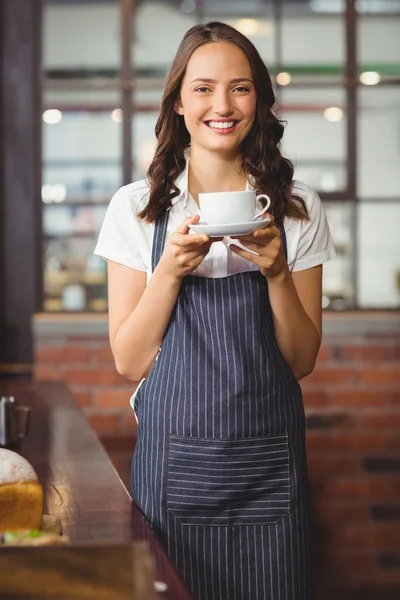 Hübsche Kellnerin bietet eine Tasse Kaffee an — Stockfoto