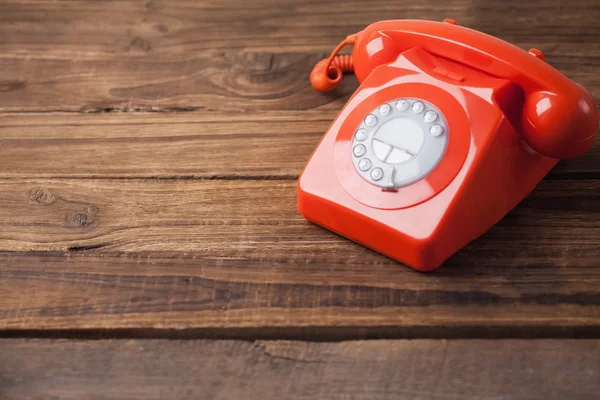 Κόκκινο τηλέφωνο στο ξύλινο τραπέζι — Φωτογραφία Αρχείου