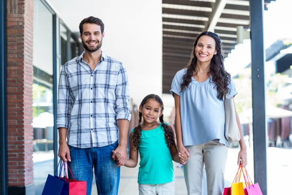 Porträtt av en lycklig familj med kassar och påsar — Stockfoto