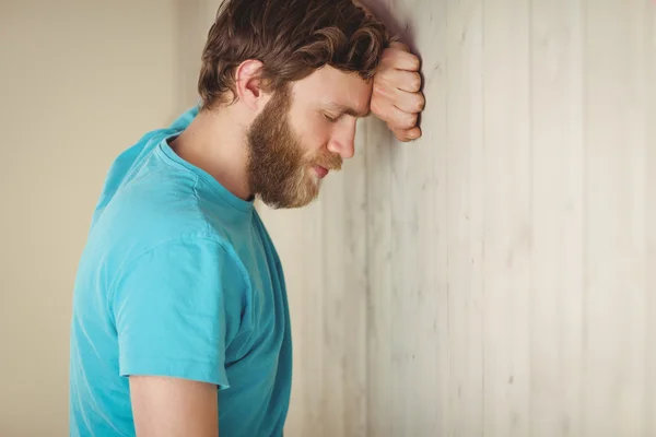 Troubled hipster leaning against wall — Stock Photo, Image