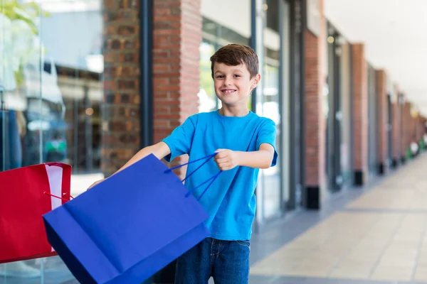 Giovane ragazzo giocare con shopping bags — Foto Stock