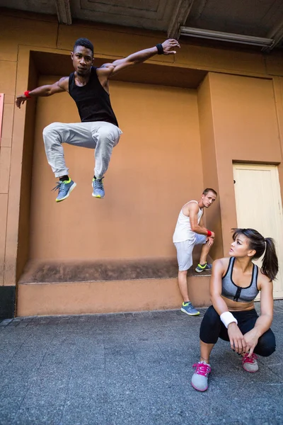 Grupo de personas haciendo parkour en la ciudad — Foto de Stock