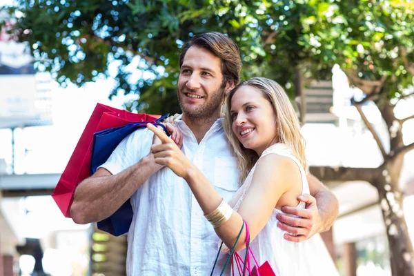 Paar knuffelen met shopping tassen — Stockfoto