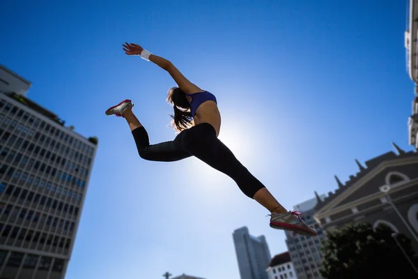 Athletic woman jumping in air — Stock Photo, Image