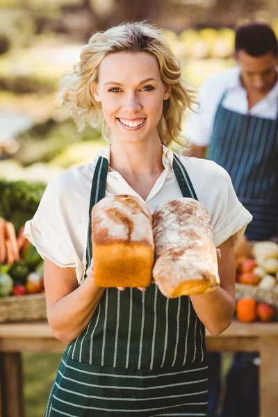 Agricultor sorrindo mulher segurando pães — Fotografia de Stock