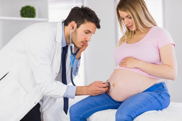Médico examinando el estómago de la paciente embarazada — Foto de Stock